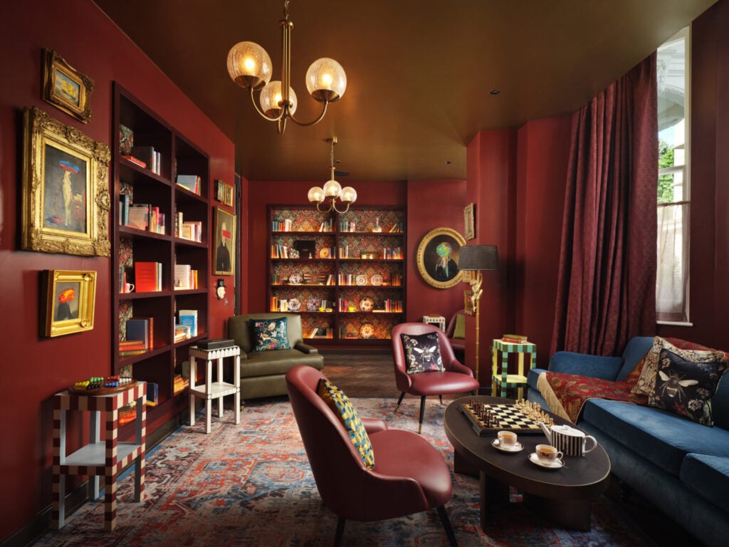 The Other House hotel interior with library and chairs looking out onto leafy street
