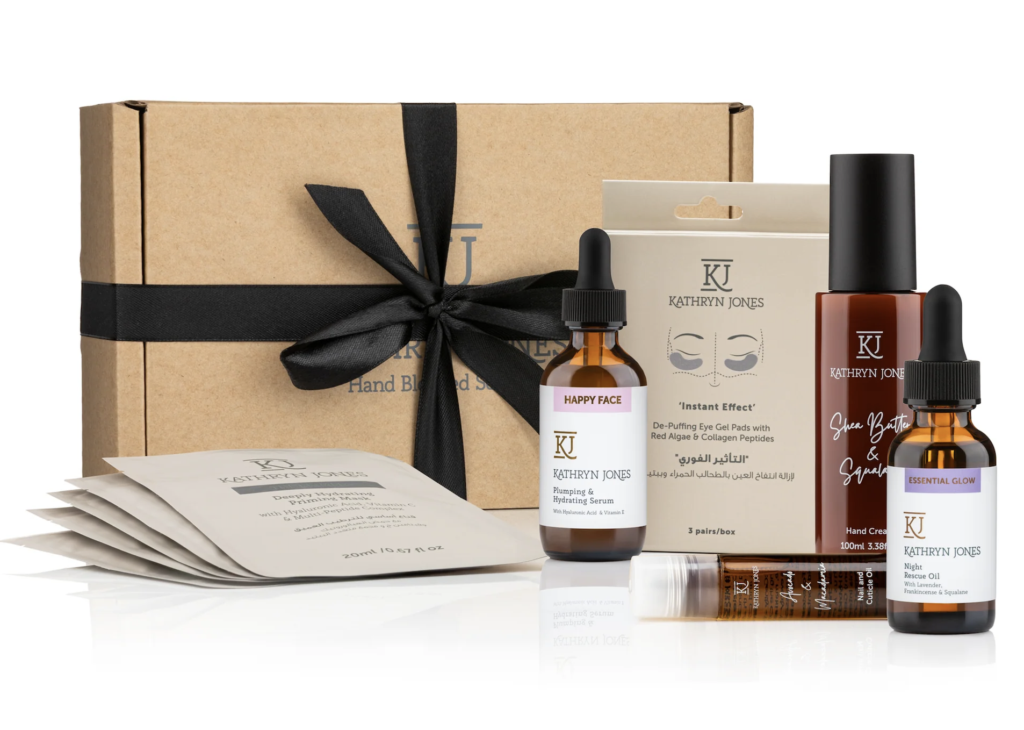 A KJ Serums gift set with black bow around cardboard box 