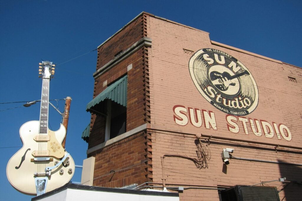 Sun Studio with guitar on a roof and a record sign on a building 