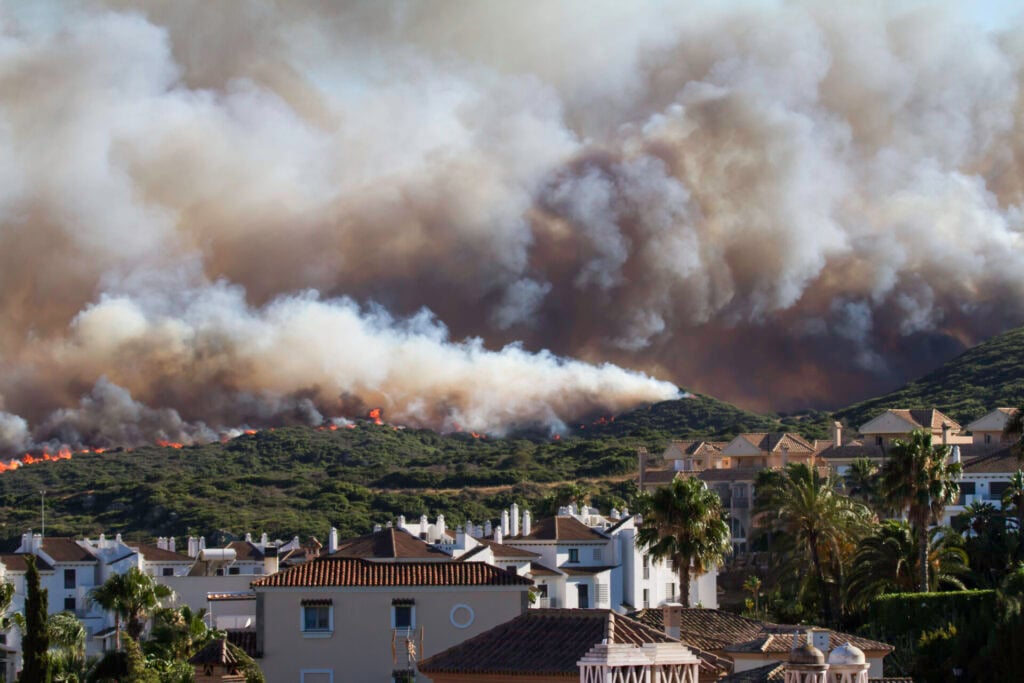 Pictures of a wildfire near houses. Wildfires were one of the biggest climate disasters in 2025