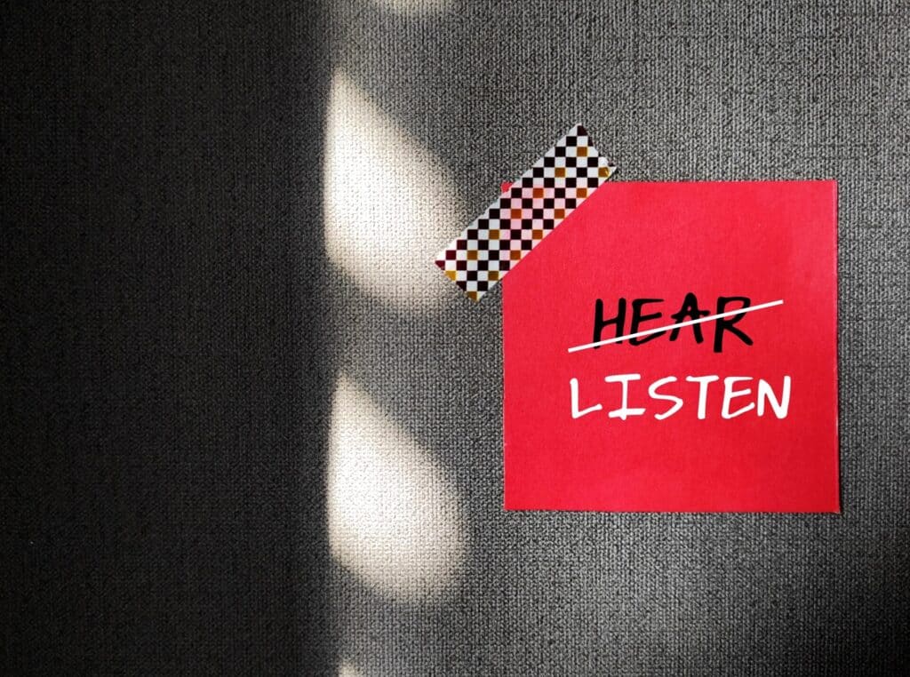 Post it with HEAR scratched out and LISTEN written in white and bold under 