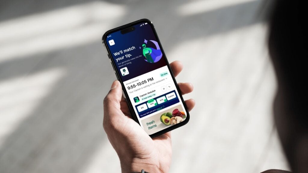 hand holding phone with Careem tip matching offer on the screen 
