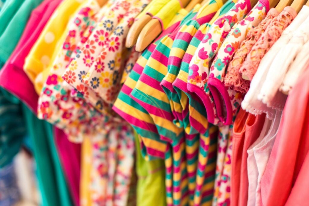 a rack of baby clothes 