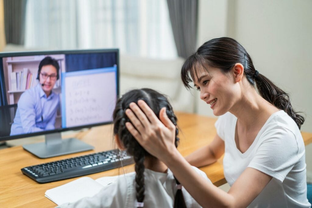 Asian parent with child on zoom conference call 
