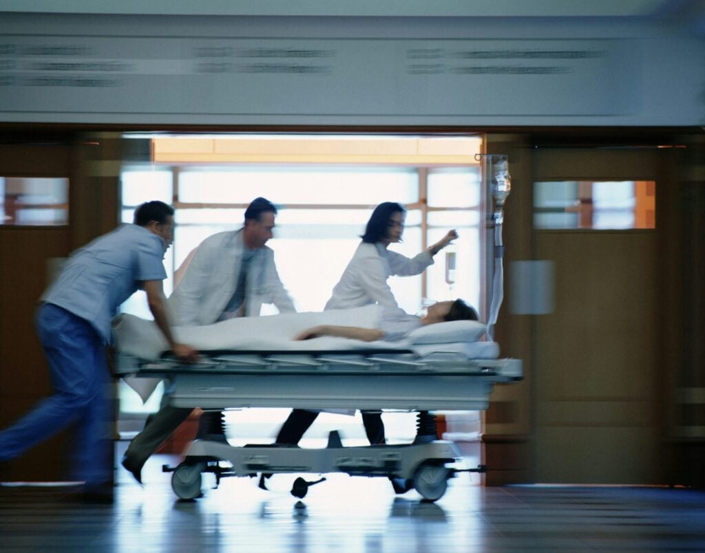 doctors rushing someone ill on a stretcher