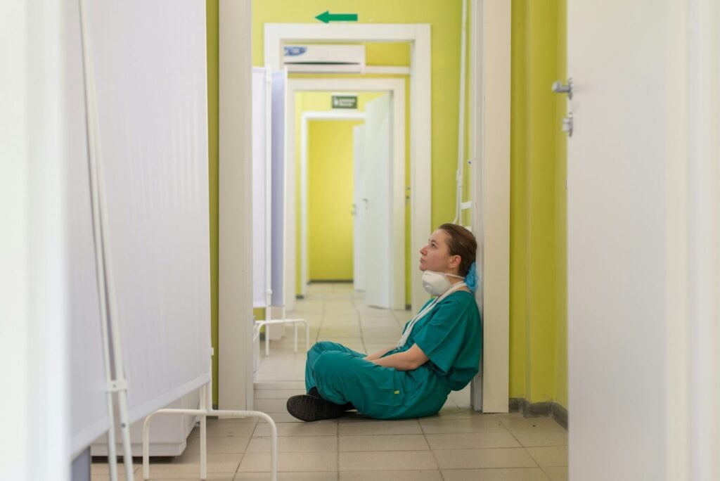 nurse sitting on the floor overwhelmed