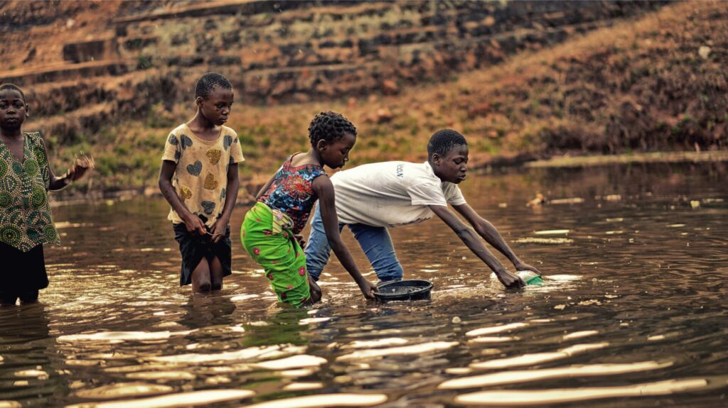 African children collecting water from a river