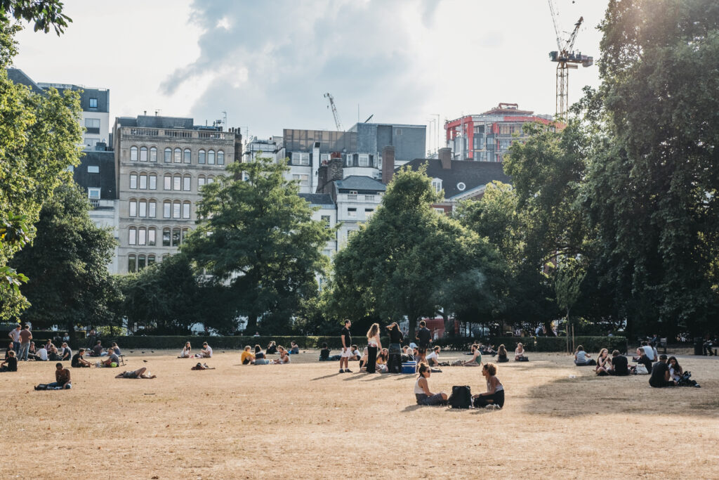 London, UK - July 24, 2018: People relaxing in Lincoln's Inn Fields during summer 2018 heatwave in London, UK. Lincoln's Inn Fields is the largest public square in London.