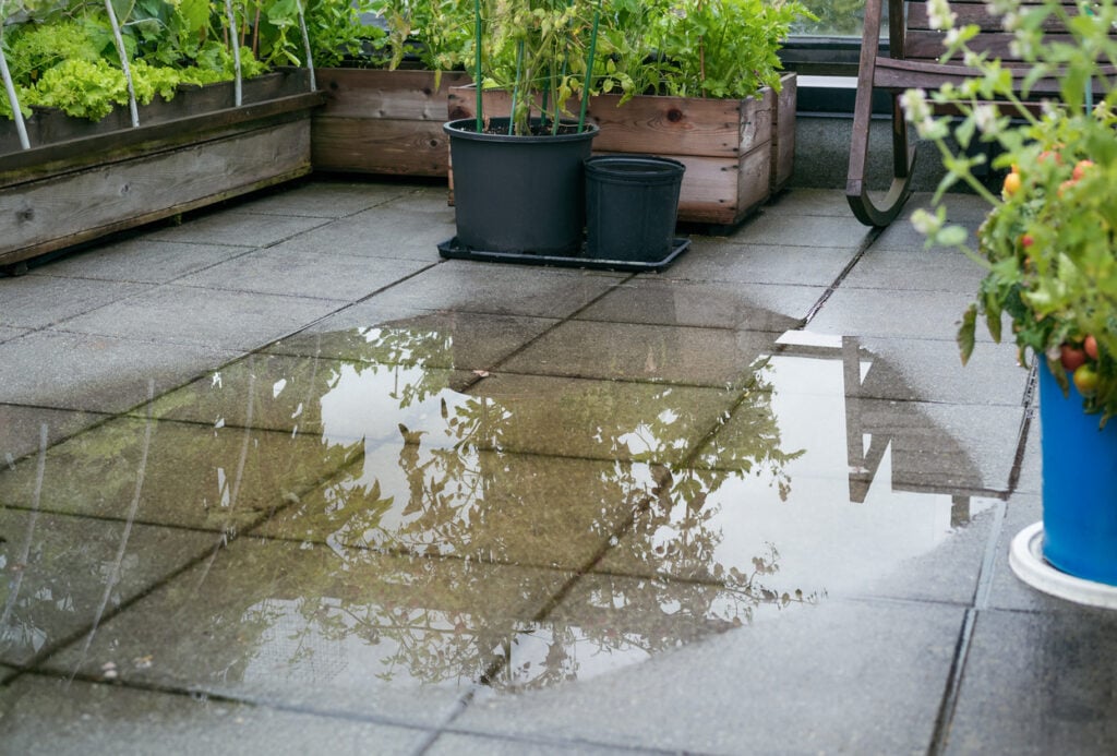 Overflowing poor drainage causes a large amount of water to pool on the tiles. Unclog the drain from mud or dirt or plumber has to snake pipe. Selective focus.