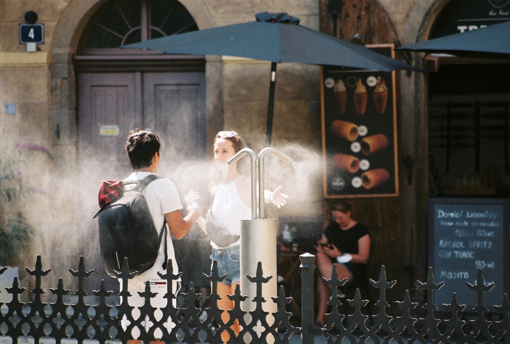 people cooling down at a water mist station in Europe 