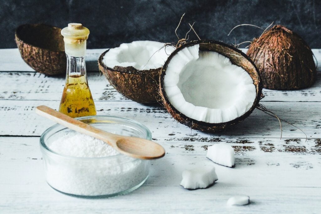 coconuts on the table with small bottle of oil as a DIY hair treatment 