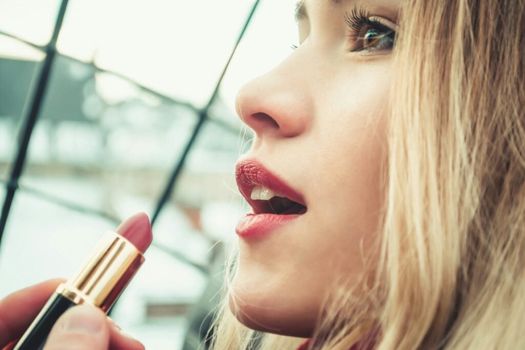 Woman applying lipstick