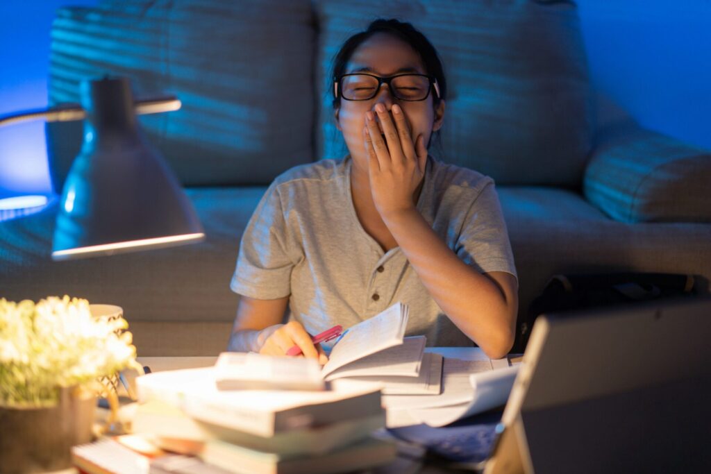 Lady yawning at night trying to study