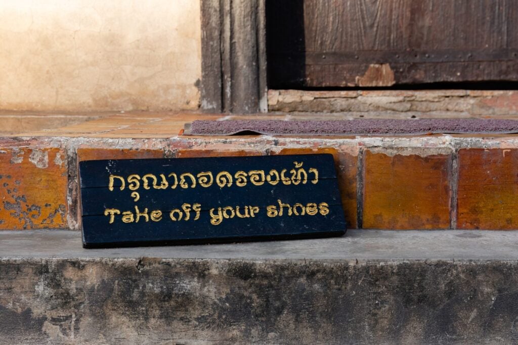 Travel etiquette sign: Take off your shoes before entering homes or religious sites