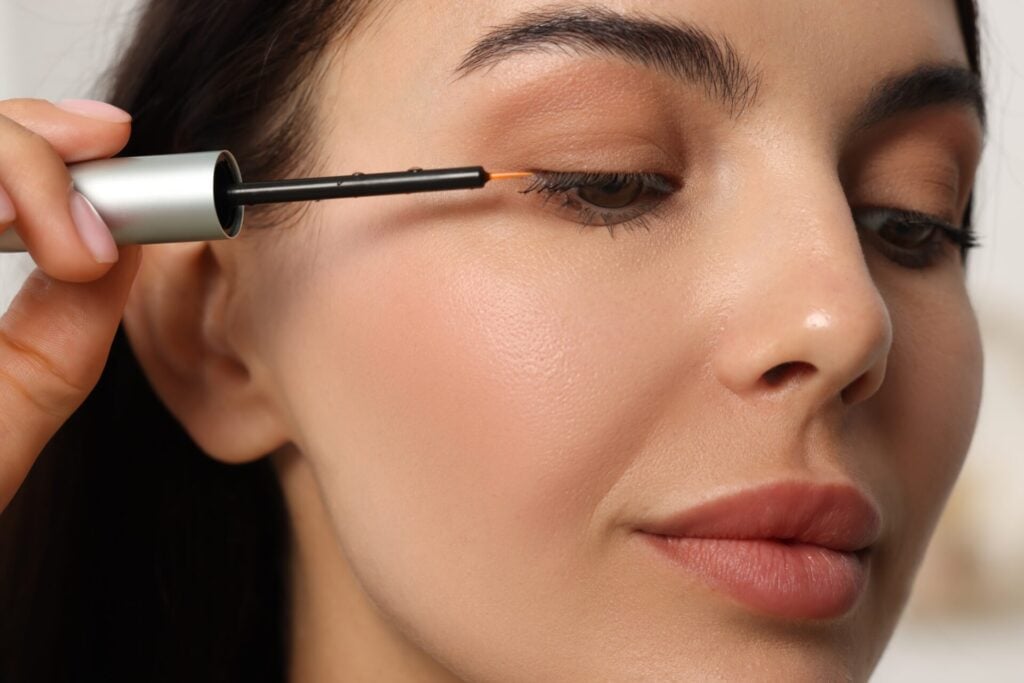 woman applying eyelash serum