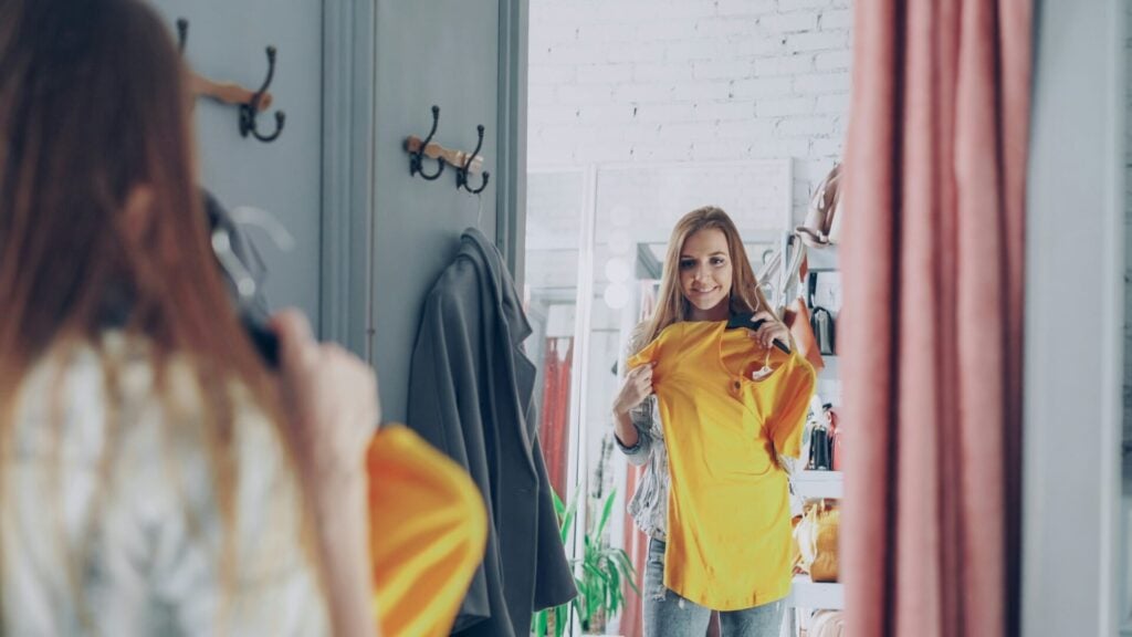 Woman trying on a T-shirt in a shop 