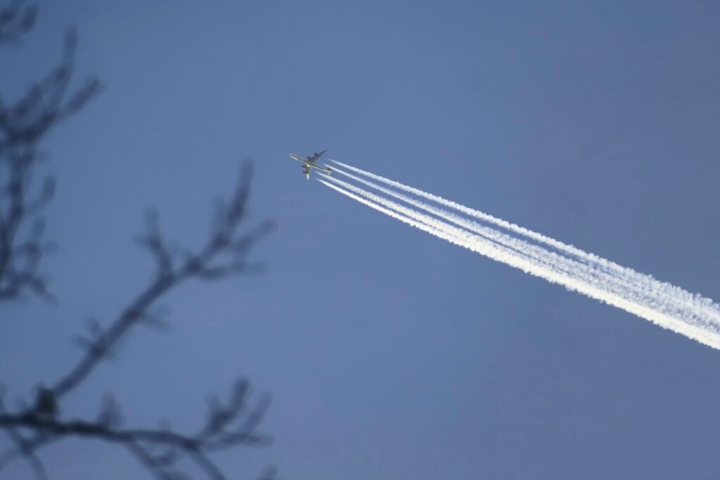 Plane in the sky with four contrails 