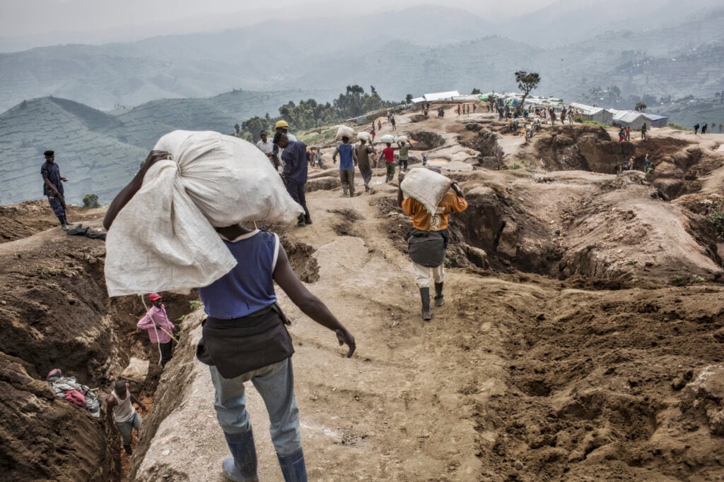 D.R. Congo, North Kivu. Coltan and manganese, are rare metals used to make mobile phones and computers. The market value is so high as to have aroused the interest of criminal organizations: in order to destabilize the political situation and take control of the mining business at a reasonable price, financial backing is given to armed groups waging war on one another. Nyatura soldiers control the territory, exploiting the local population and reselling its natural resources: the proceeds are used to buy other weapons that provide additional power, thus creating a vicious circle it is difficult to break. Nyatura survive by bullying, through abuse of power, abuse of civilians, raiding night and day and demanding tax on all forms of activity in the city of Rubaya. Soldiers patrol the territory around the Mudere mine where miners dig 20 meters underground. After workers transporting minerals to a nearby river where they are separated from rocks and sand before being sold to dealers.