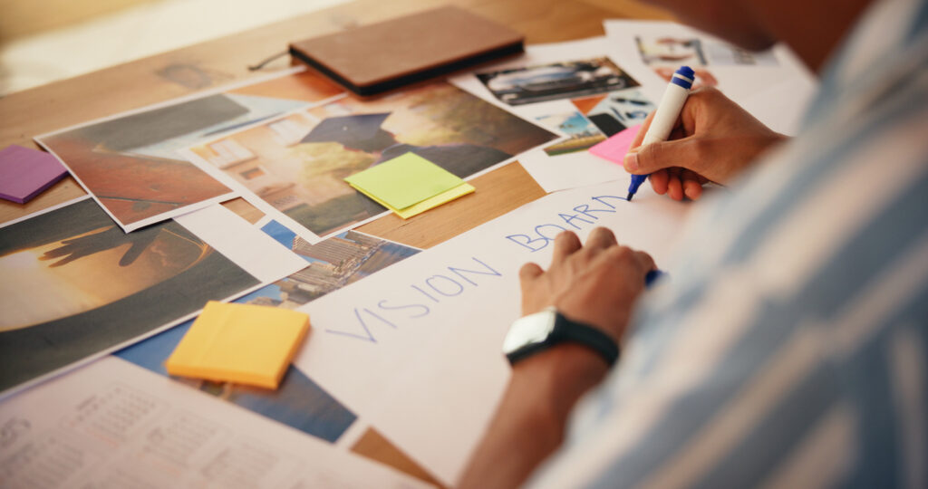 Hands, planning and writing on vision board in home for growth rituals, aspirations design and manifestation