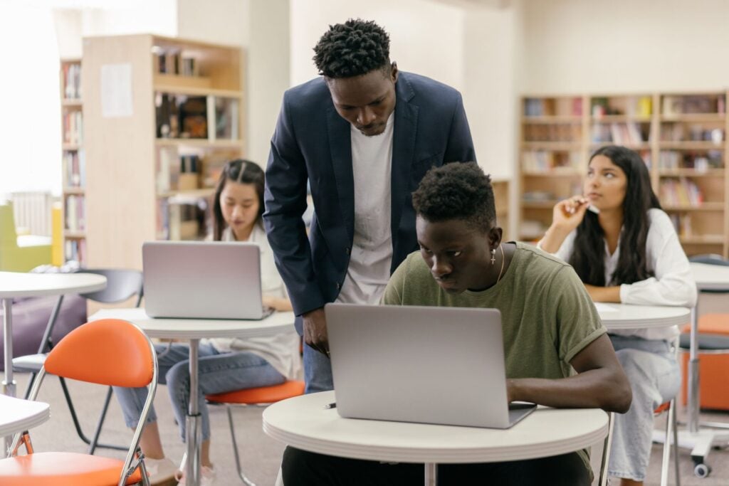 teacher with students learning on laptops