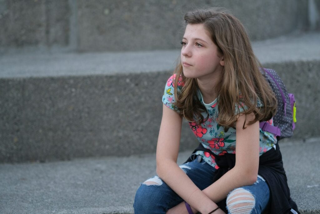 teenager looking perplexed with backpack still on