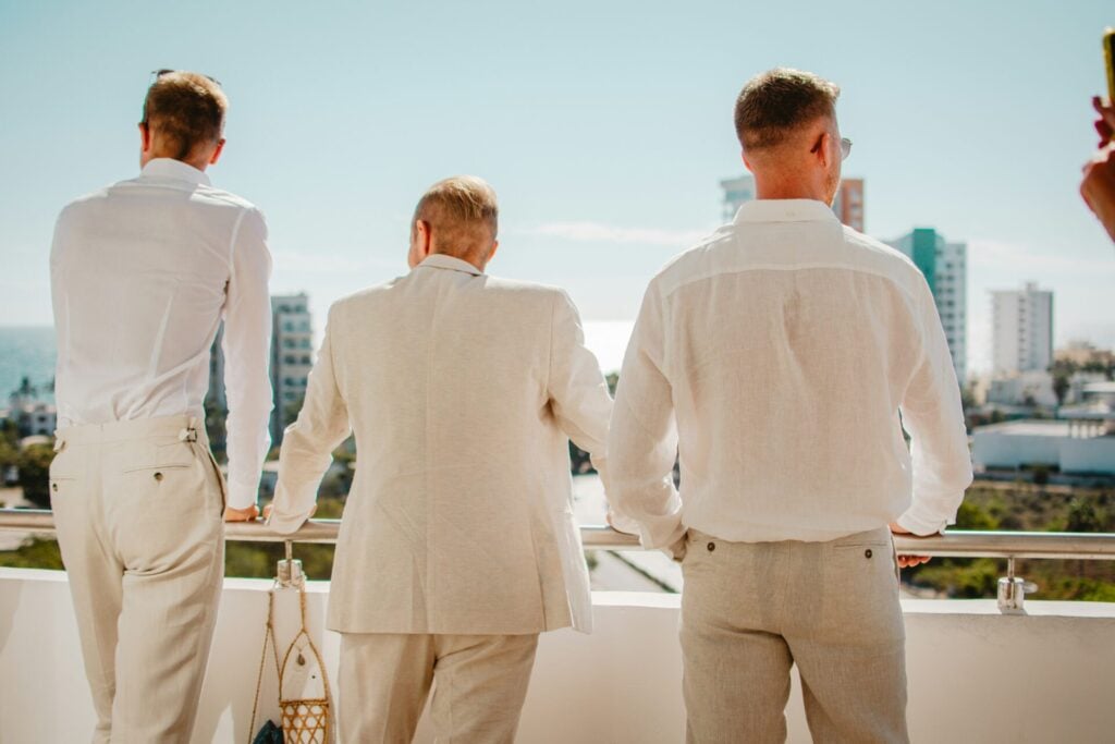 men in linen suits on a balcony