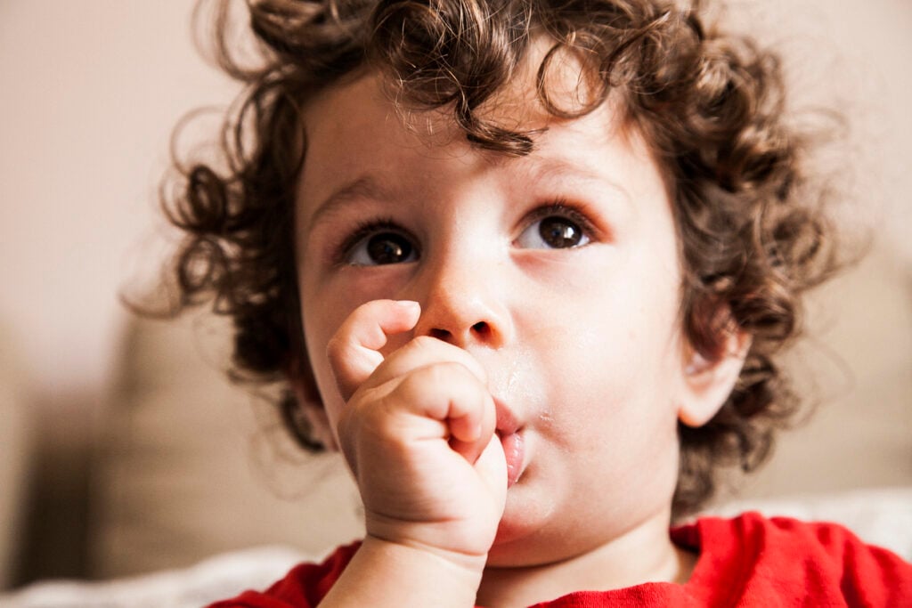 Baby sucking thumb on couch
