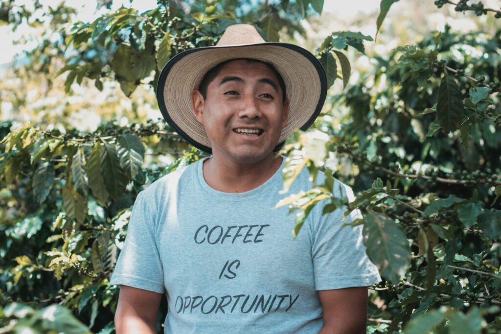 man with a T-shirt saying "coffee is opportunity" as a way to support fair trade farmers on International coffee day