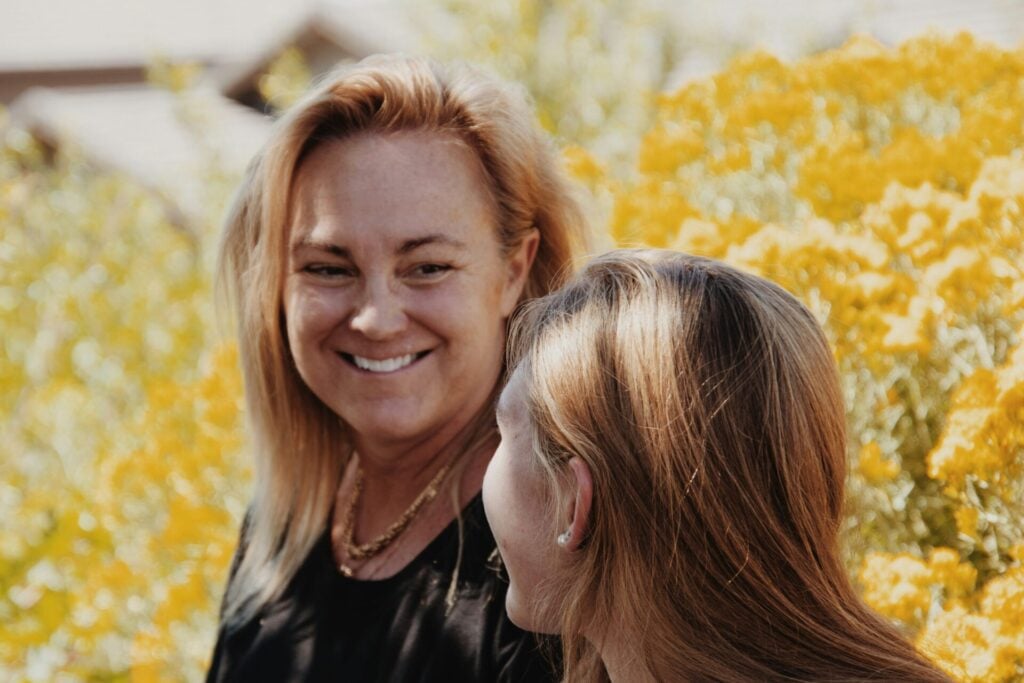 mother smiling tallking to her teenage daughter on a walk